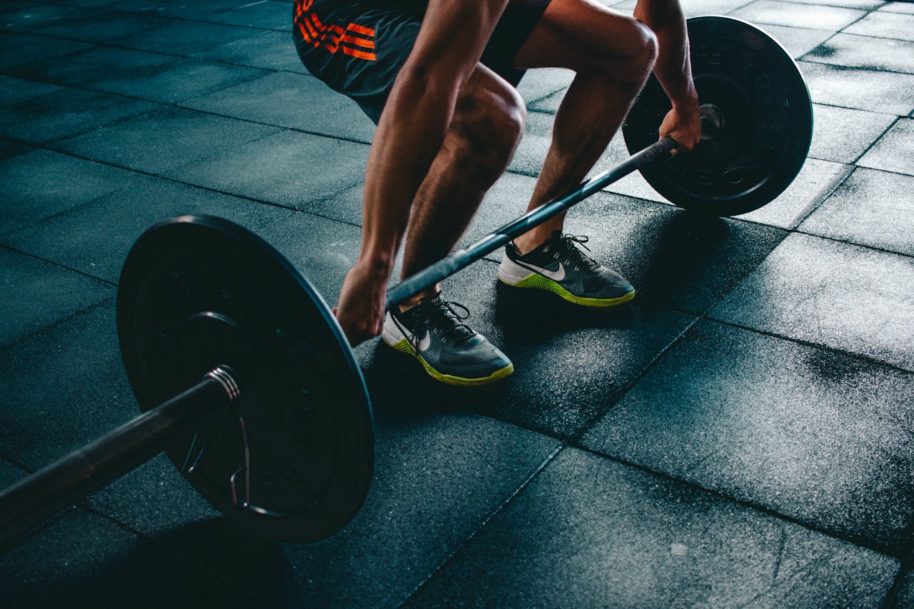 services-08 Man performing a deadlift exercise in a gym, demonstrating strength and fitness.